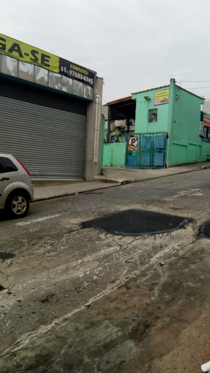 Em frente a um galpão comercial, buraco no asfalto é fechado, na rua Felipa Gago